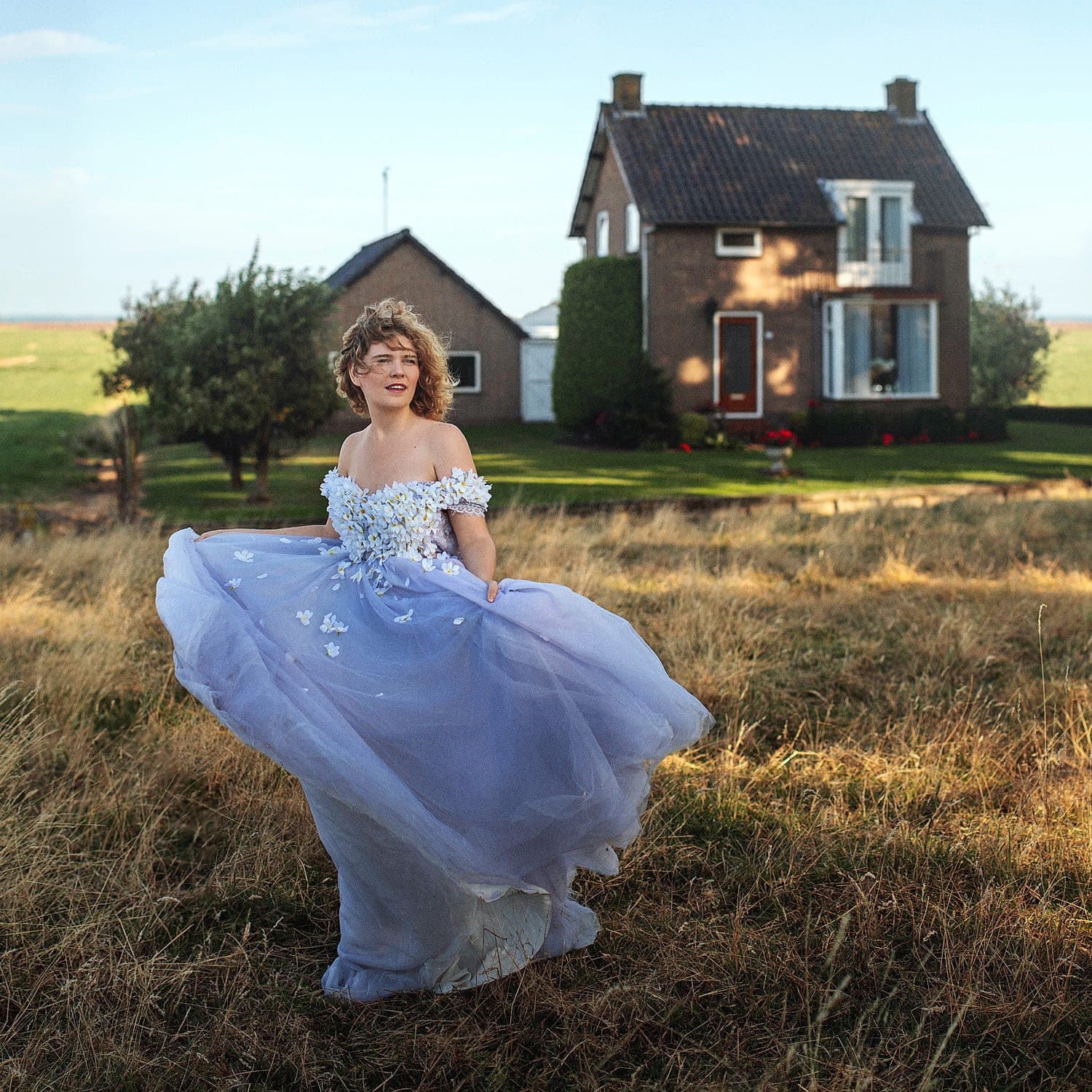 NinaLynn in een veld bij een boerderij